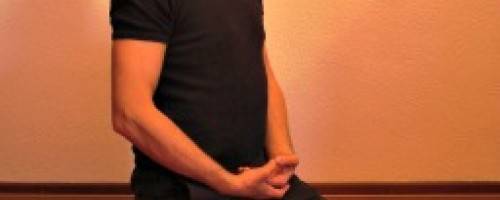 man kneeling with hands folded relaxing